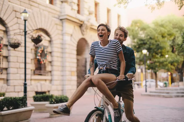 smiling couple on a bicycle 